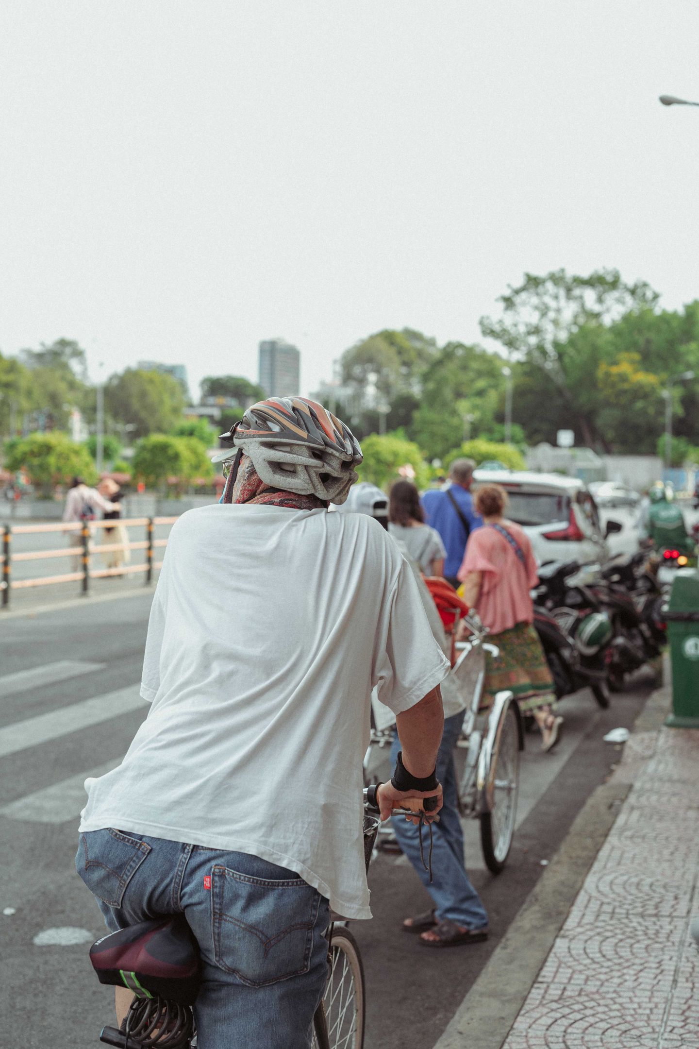 A helmeted cyclist riding through a busy city street