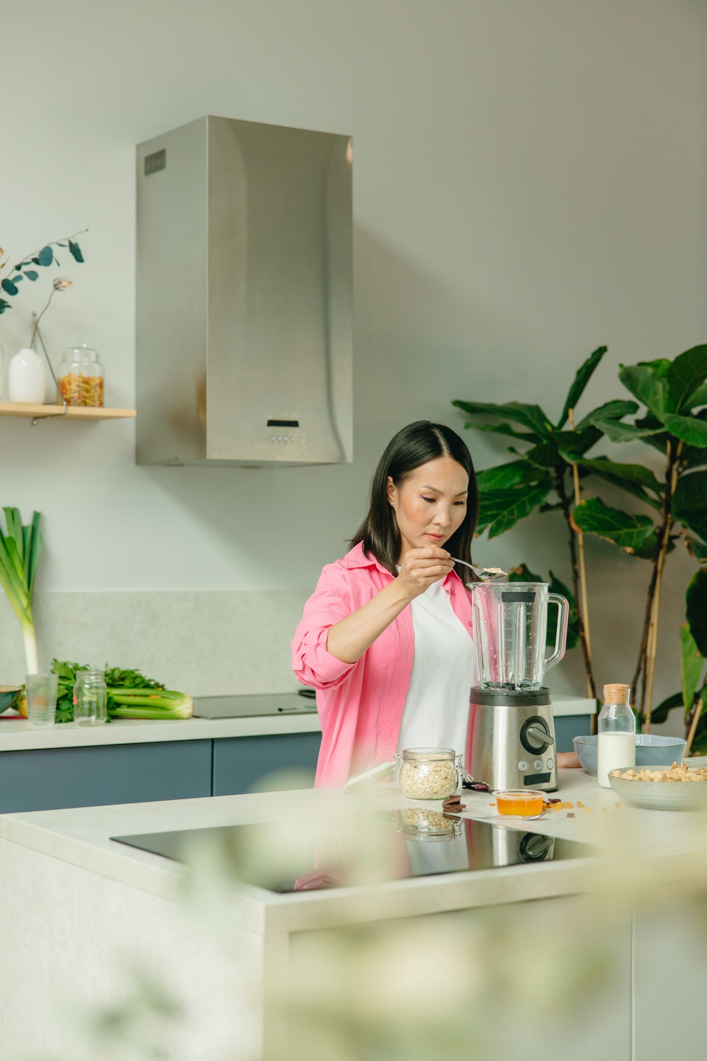 A person blending a smoothie at a home kitchen counter