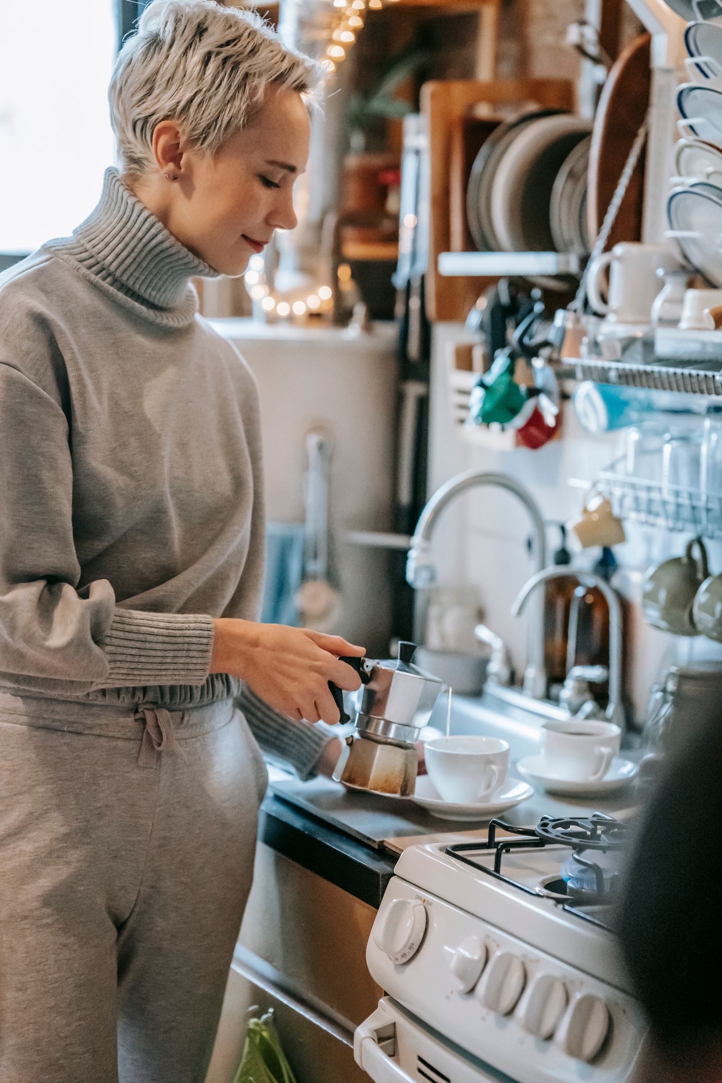 A person preparing coffee in a warm home kitchen