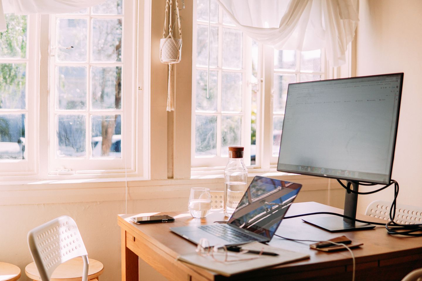 A laptop set up on a sunlit home-office desk