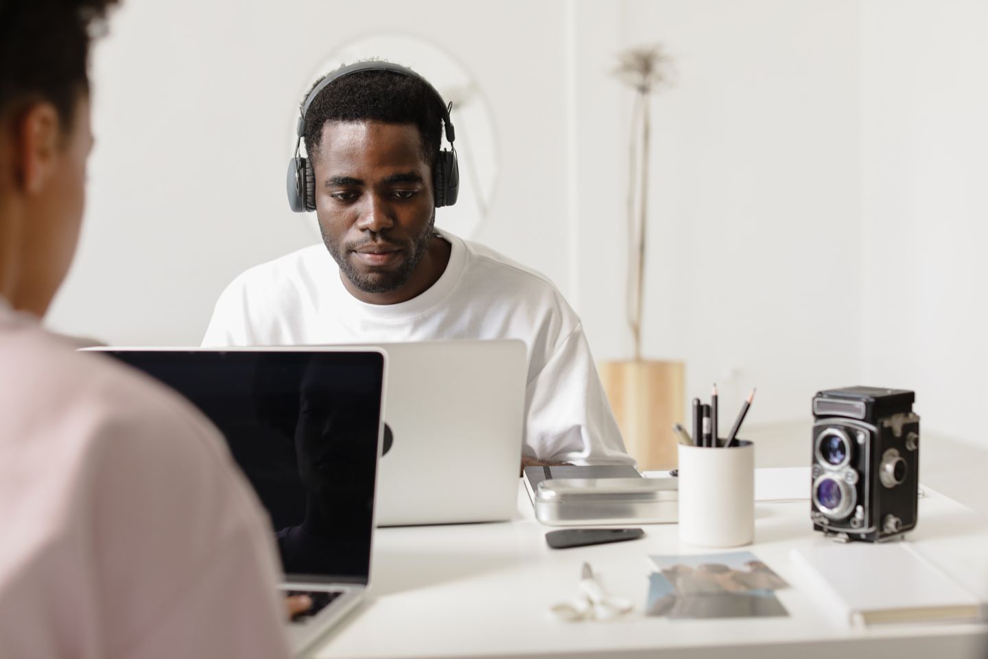 A person working on a laptop while wearing headphones