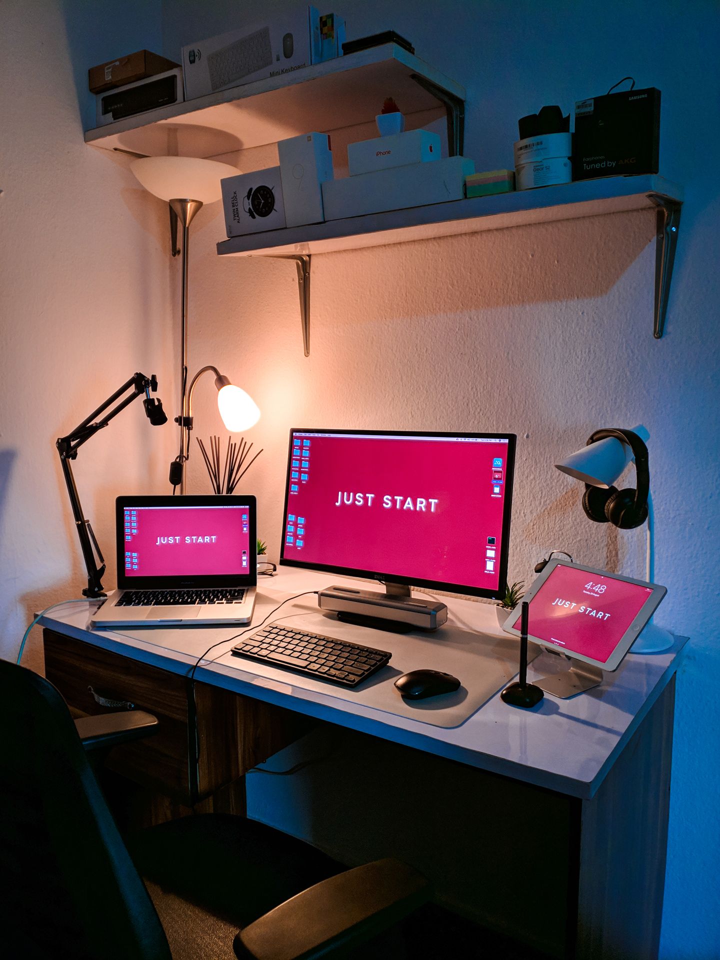 A laptop, monitor, and desk accessories in a softly lit workspace