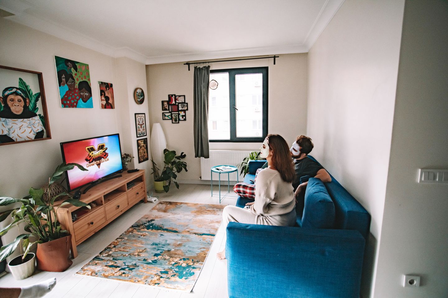 A couple relaxing in a living room with a television and indoor plants