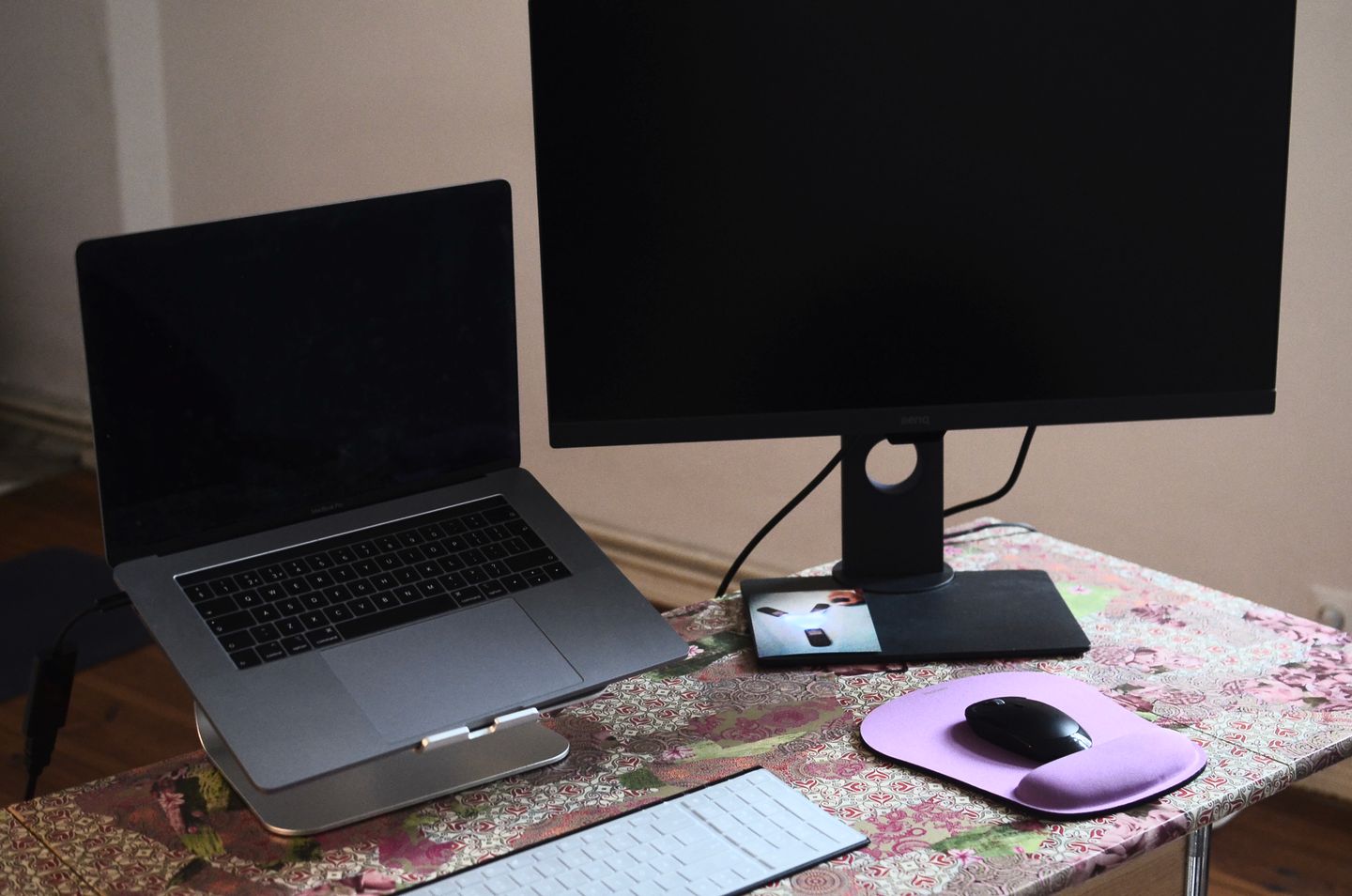 A laptop and monitor arranged on a desk with a keyboard and mouse