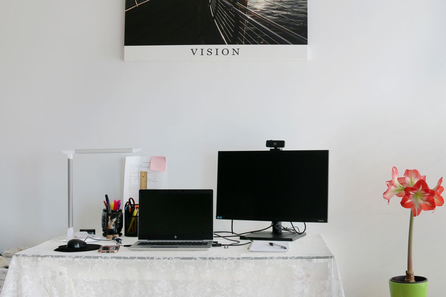 A laptop, monitor, and webcam arranged in a bright home office