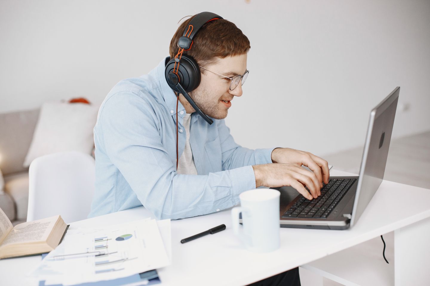 A person wearing headphones and joining a video call from a laptop